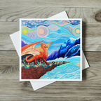 Colourful dragon illustration on a greeting card with a white envelope on a wooden surface
