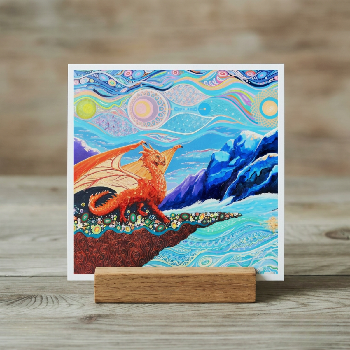 Colourful abstract art print of a dragon on a wooden stand against a wooden background