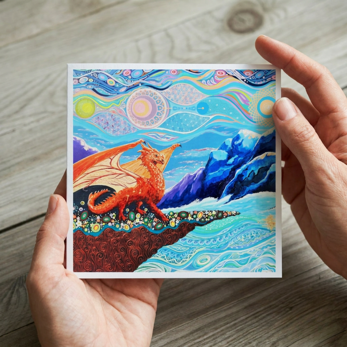 Card with a dragon design held by hands on a wooden surface