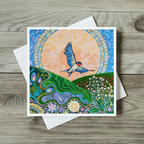 Colourful greeting card with a bird and nature design on a wooden surface