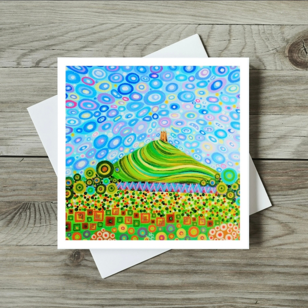 Colourful abstract landscape card on a wooden surface