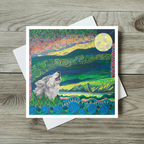 Greeting card with a wolf howling at the moon design on a wooden surface