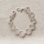 Silver spiral bracelet on a fabric surface