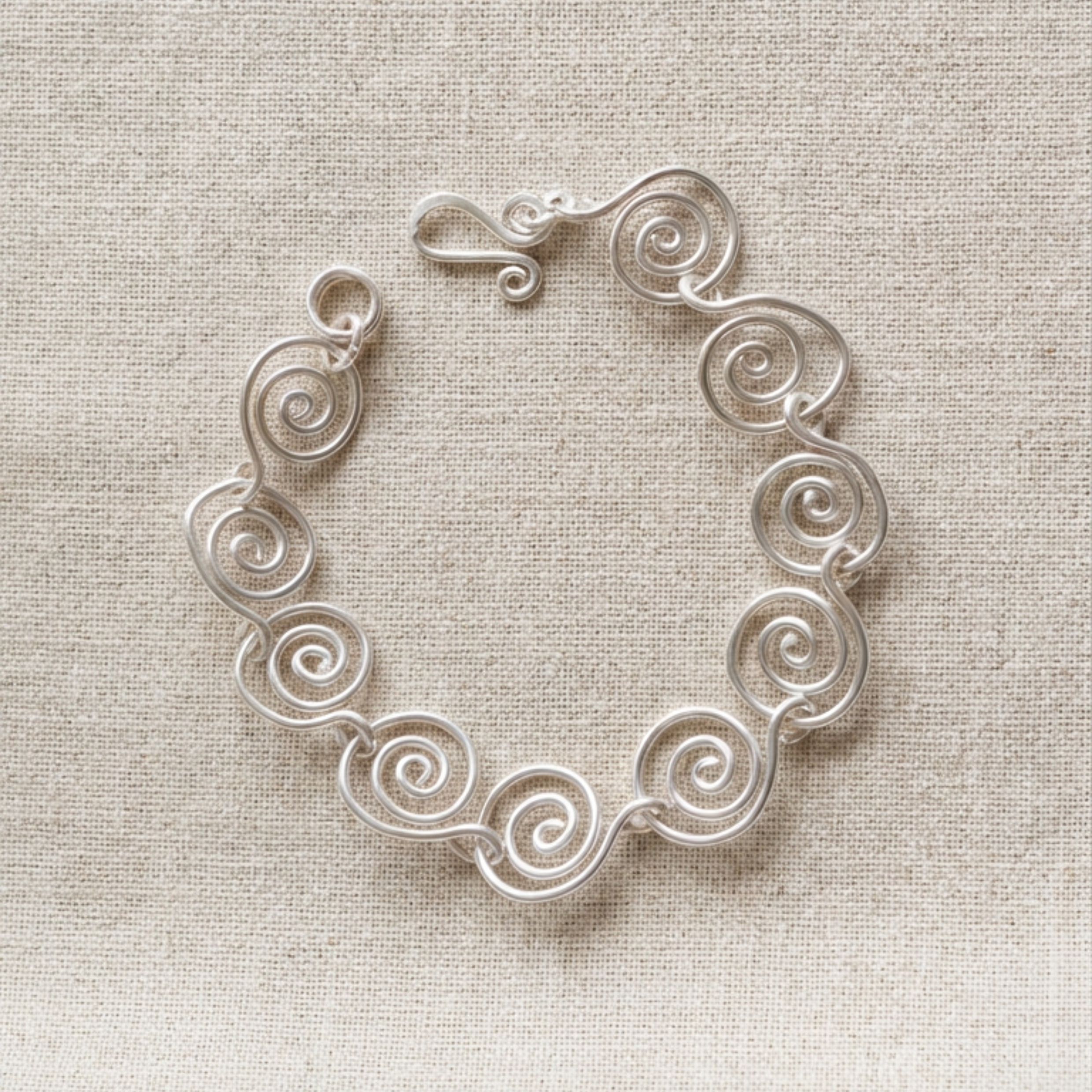 Silver spiral bracelet on a fabric surface