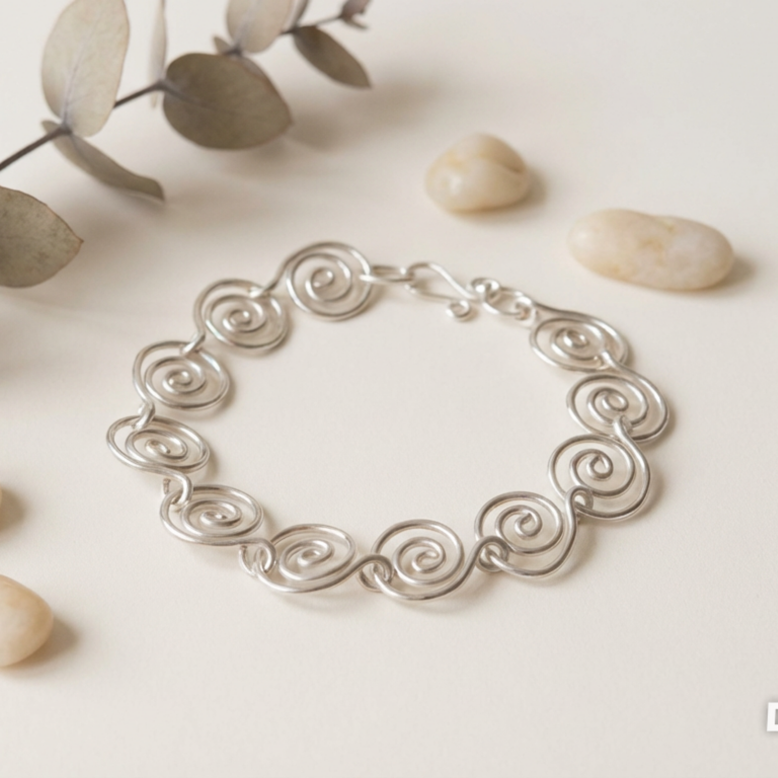Elegant silver spiral bracelet on a white surface