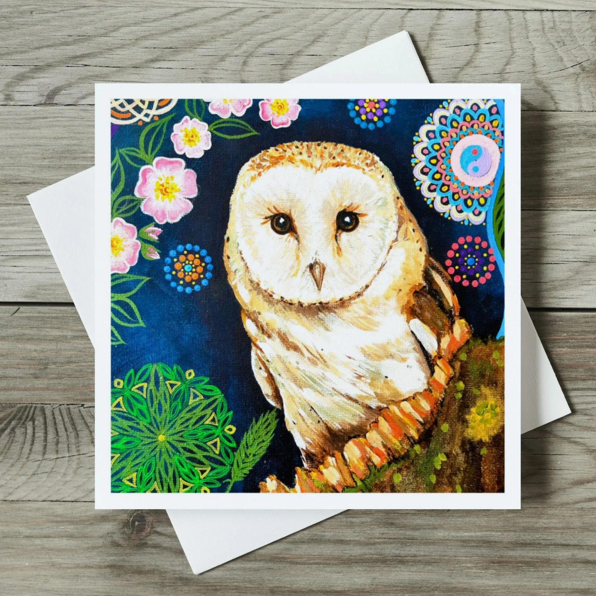 Greeting card with a colourful owl illustration on a wooden surface