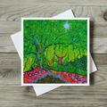 Colorful nature-themed greeting card with a deer in a forest design on a wooden surface.