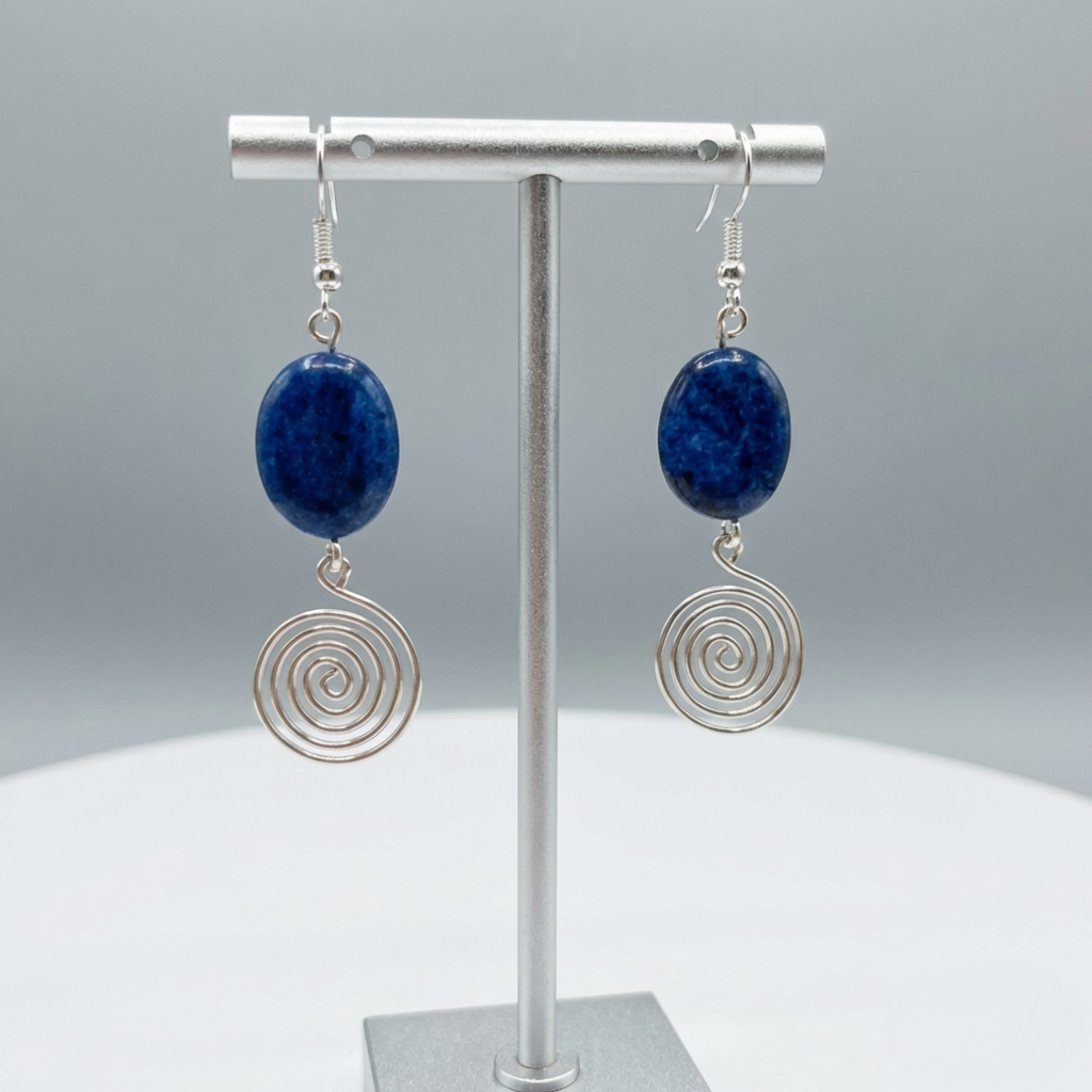 Pair of earrings with blue stones and silver spiral designs on a grey background