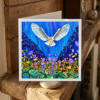 Colourful artwork of a bird flying over a vibrant landscape on a wooden surface.