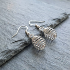 Silver spiral earrings on a grey stone surface
