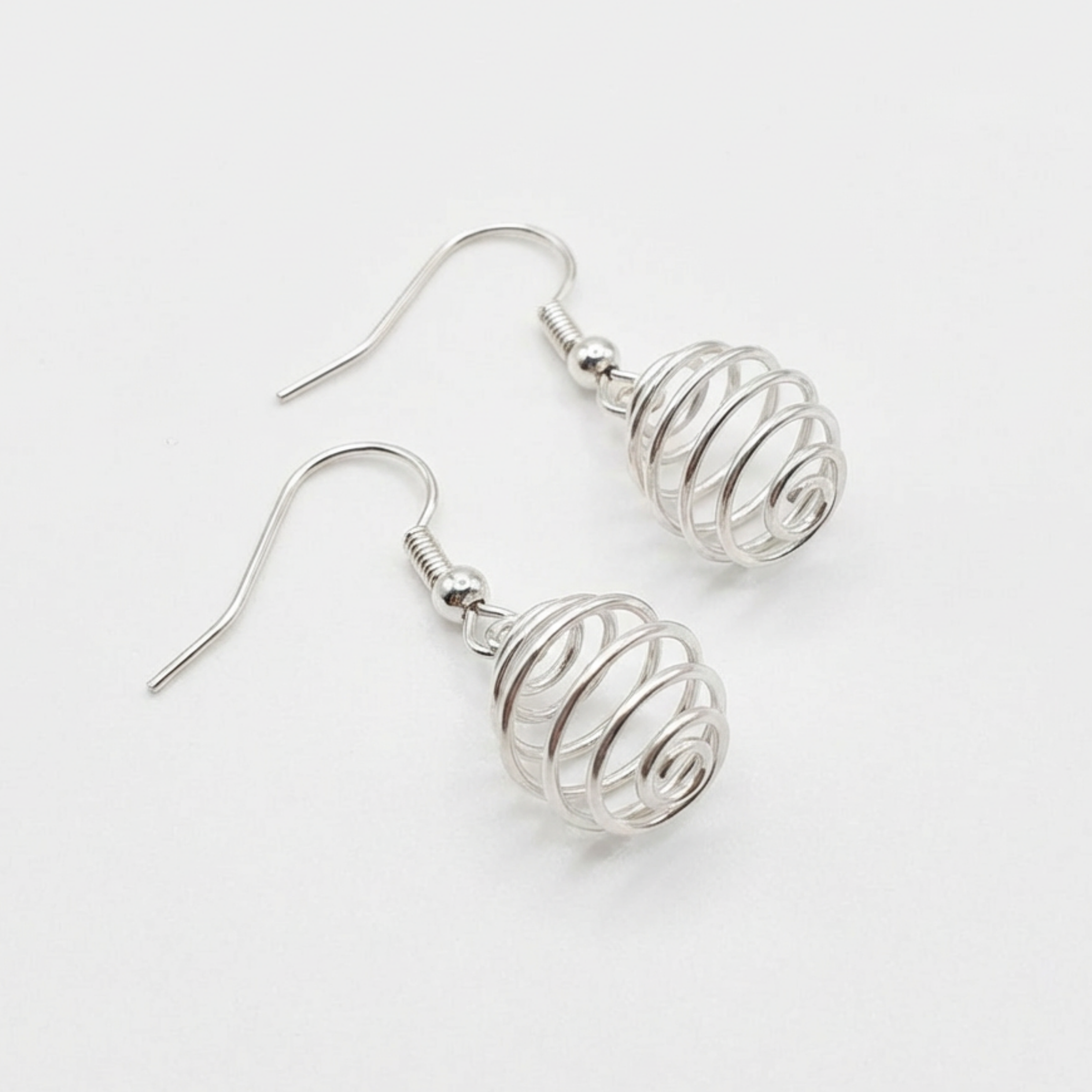 Silver wire-wrapped earrings on a white background