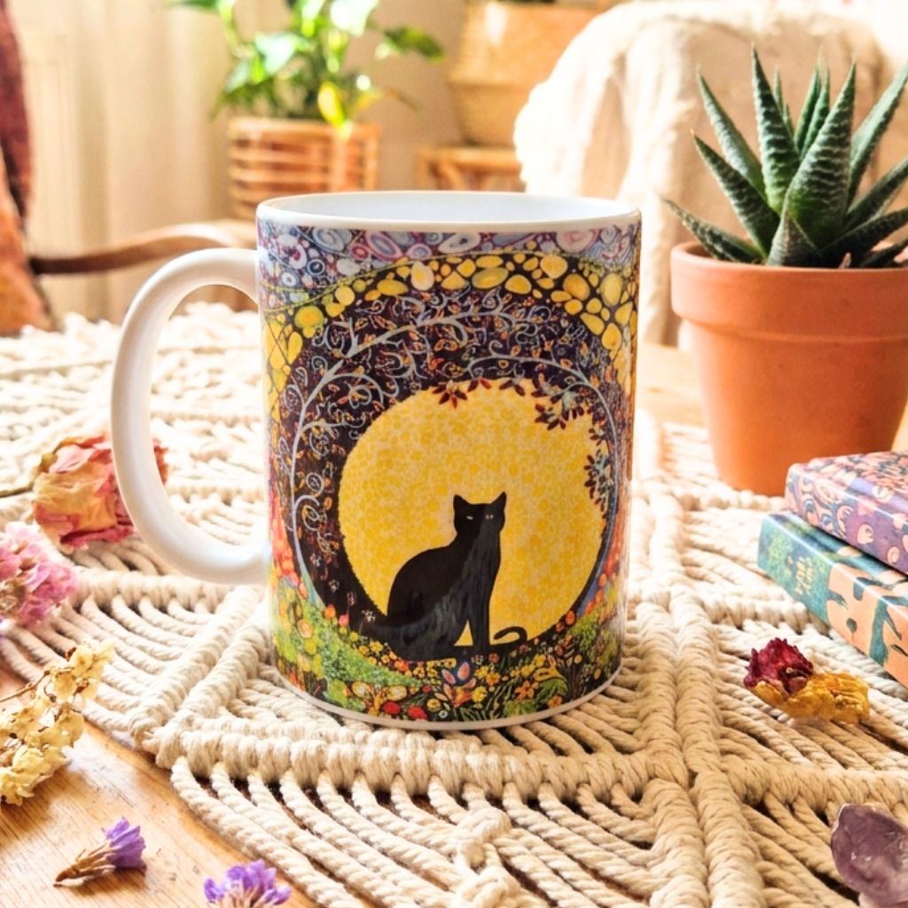 Mug with a black cat design on a textured surface with plants and books in the background