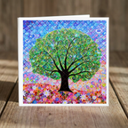 Colourful card with a tree of life design on a wooden surface