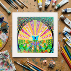 Colourful abstract artwork with a butterfly on a wooden surface with art supplies.