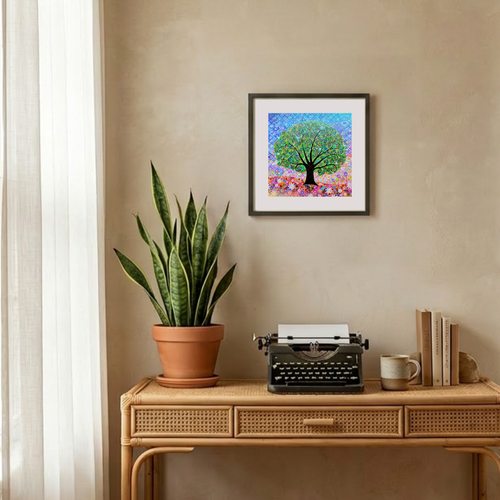 Decorative setup with a potted plant, typewriter, and framed artwork on a wooden table.