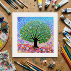 Colourful tree artwork on a wooden surface with art supplies