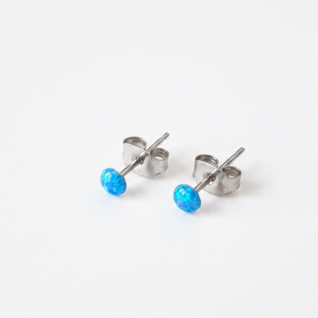 Pair of silver stud earrings with blue gemstones on a white background