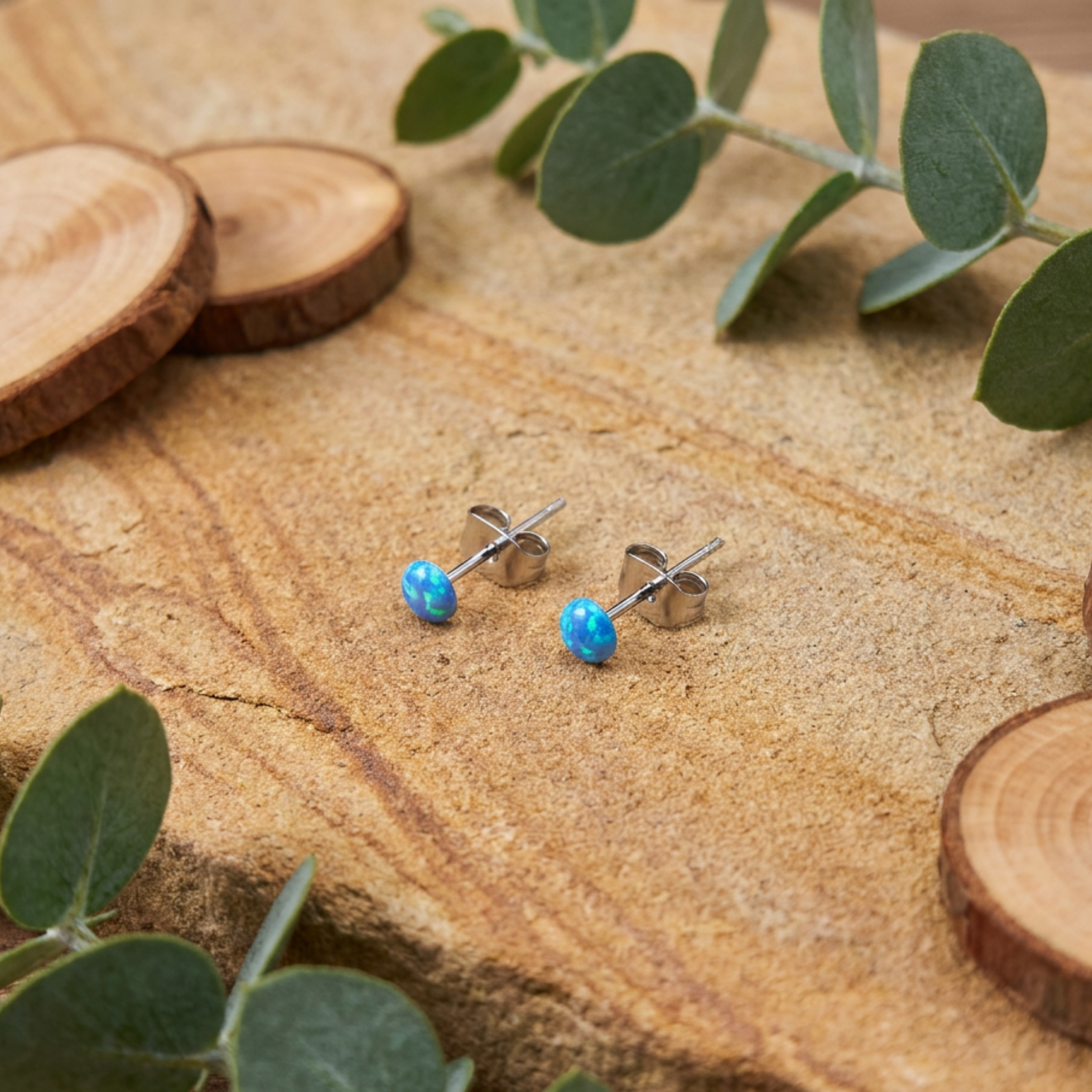 Blue spot stud earrings on a rustic backdrop