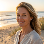 woman wearing blue dot resin earrings on the beach