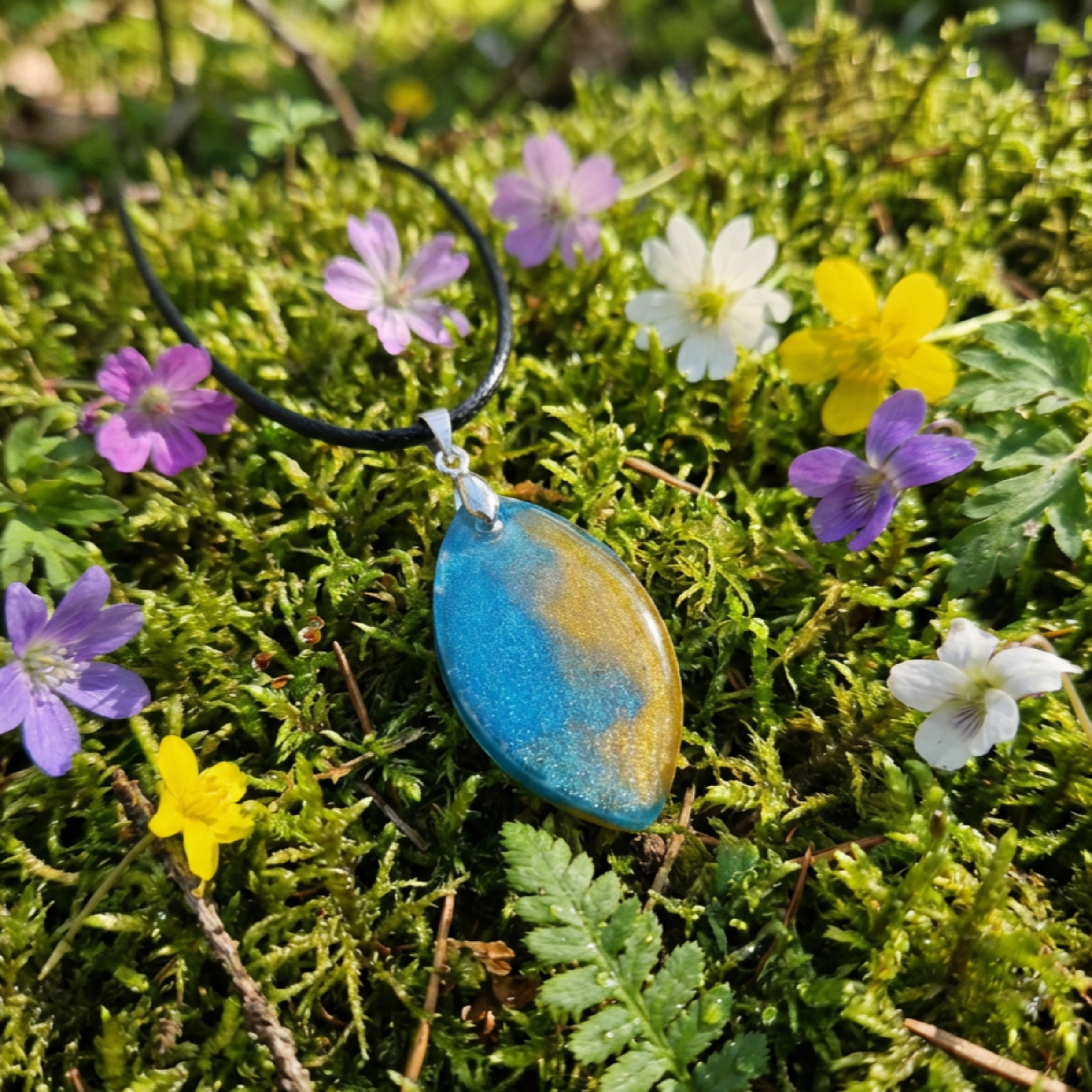 Blue and Gold oval pendant on moss