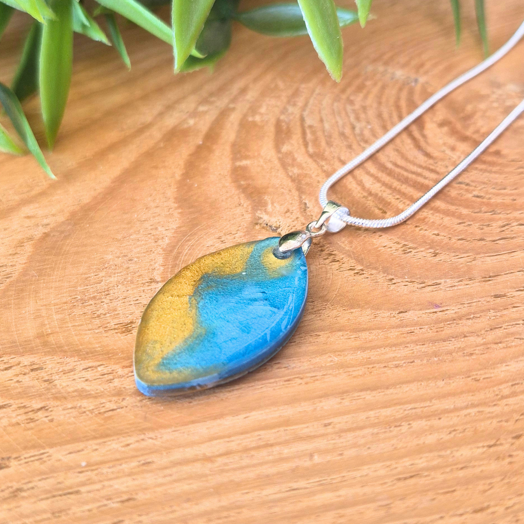 Striking blue gold pendant on a wooden surface