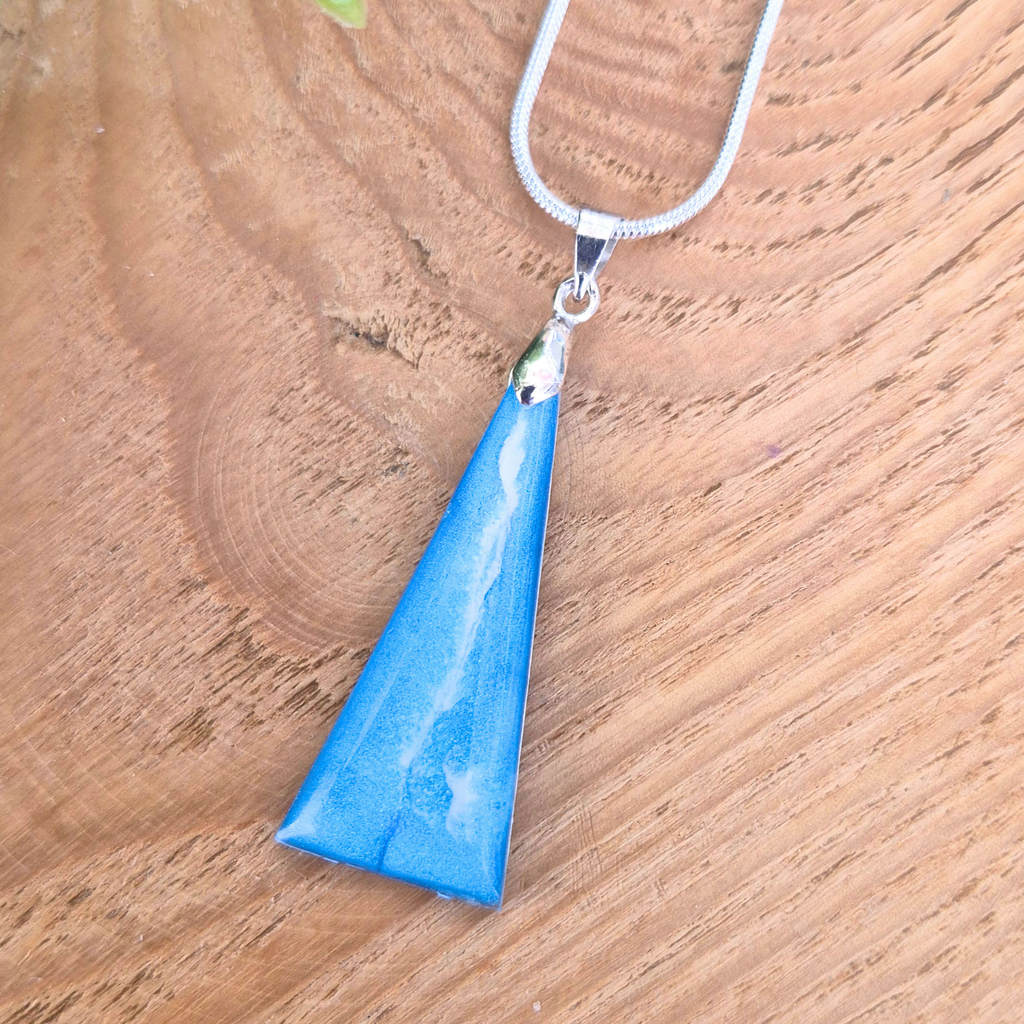 Blue pendant necklace on a wooden surface