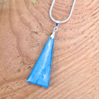 Blue pendant necklace on a wooden surface