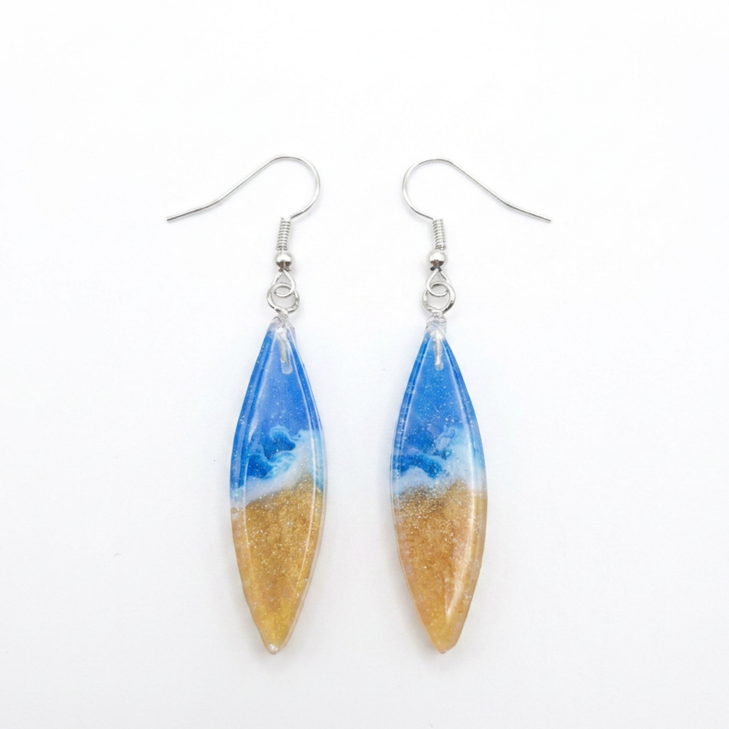 Pair of earrings with blue and gold design on a white background