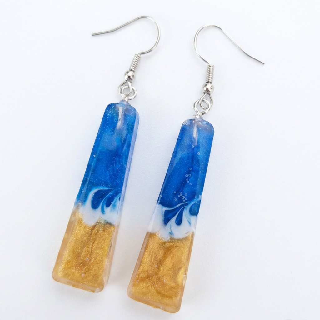 Pair of earrings with blue and gold design on a white background
