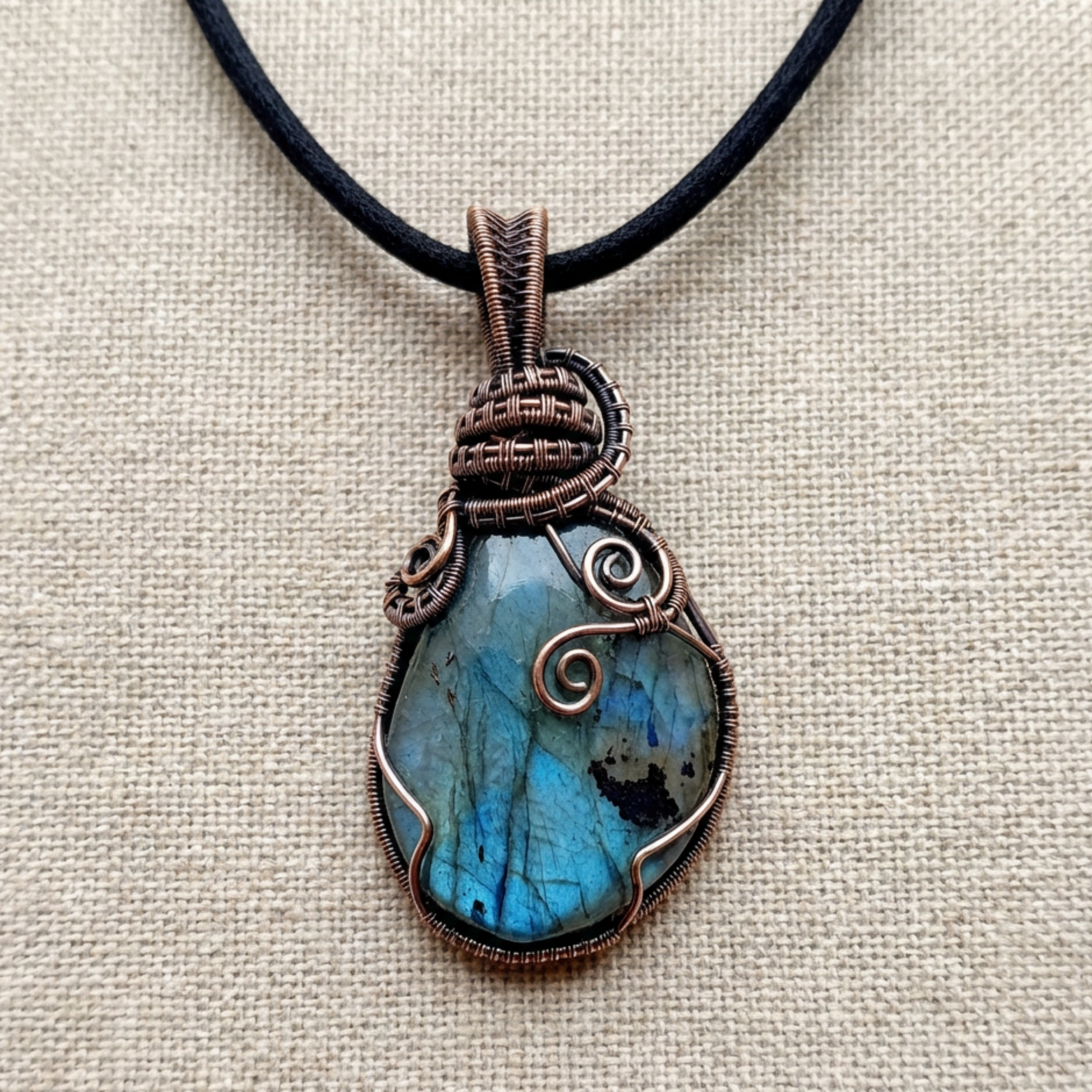 Necklace with a blue stone pendant on a beige fabric background