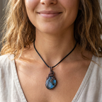 Close-up of a woman wearing a necklace with a blue labradorite pendant.