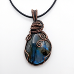 Necklace with a pendant featuring a blue stone and copper wire wrapping on a white background
