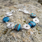 Bracelet with blue and brown beads on a textured stone surface