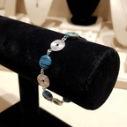 Bracelet with blue and silver beads on a black stand
