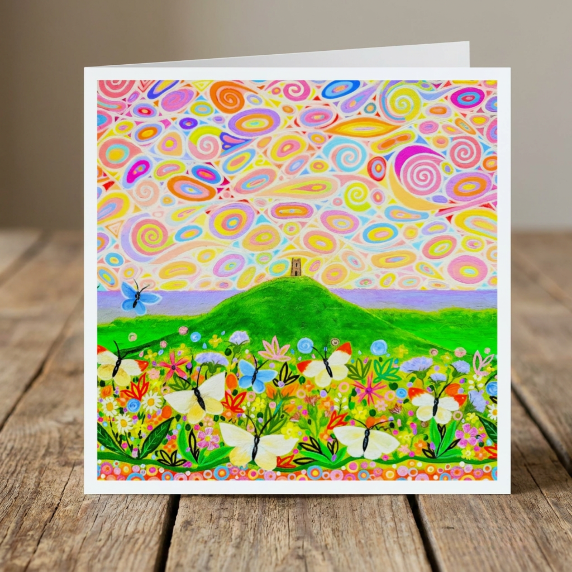 Colourful card with abstract patterns and nature scene on a wooden surface