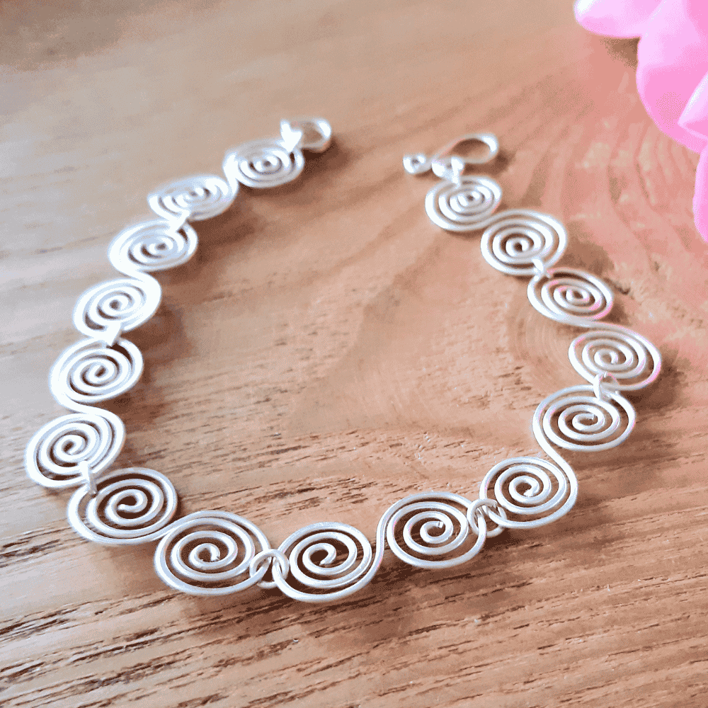 Celtic silver spiral bracelet on a wooden surface