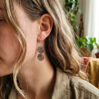 Celtic copper spiral earrings worn by model, rustic handmade jewellery UK
