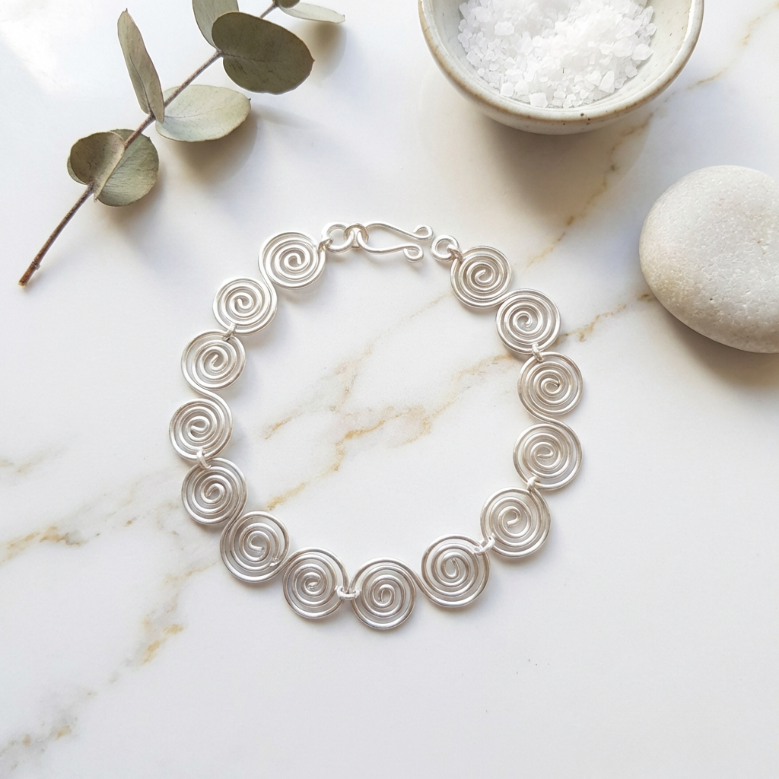 S shaped spiral bracelet on a marble surface