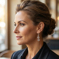Woman wearing a black blazer with a blurred indoor background and a pair of Celtic silver spiral earrings