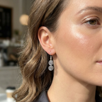 Close-up of a woman wearing silver spiral earrings with a blurred background