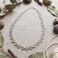 Delicate silver spiral necklace laying flat on fabric