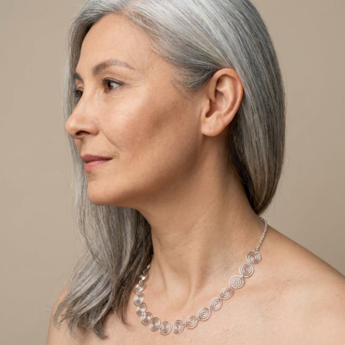 Lady wearing a Celtic silver spiral necklace with a chain