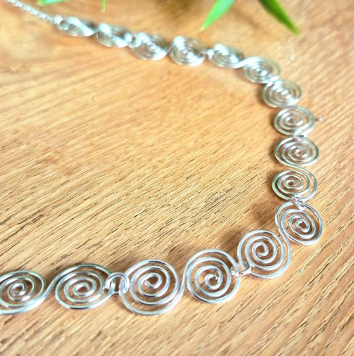 S shaped spirals forming a chain of spirals make up this silver spiral necklace