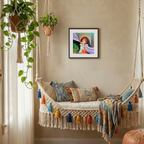 Decorative indoor swing with colourful pillows and a framed painting on the wall.