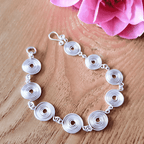 Circular spiral chain bracelet on a wooden surface