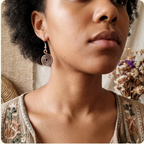 Close-up of a woman wearing a copper spiral earring with a neutral background