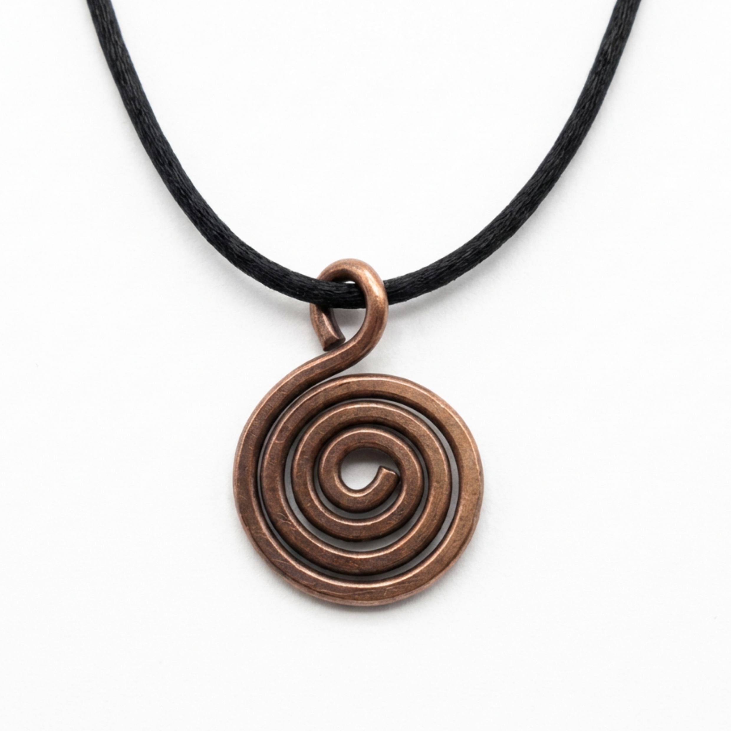 Copper spiral pendant on a black cord against a white background