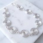 Silver spiral bracelet on a marble surface