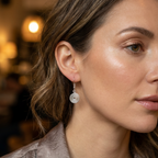 Close-up of a woman wearing silver spiral earrings with a blurred background