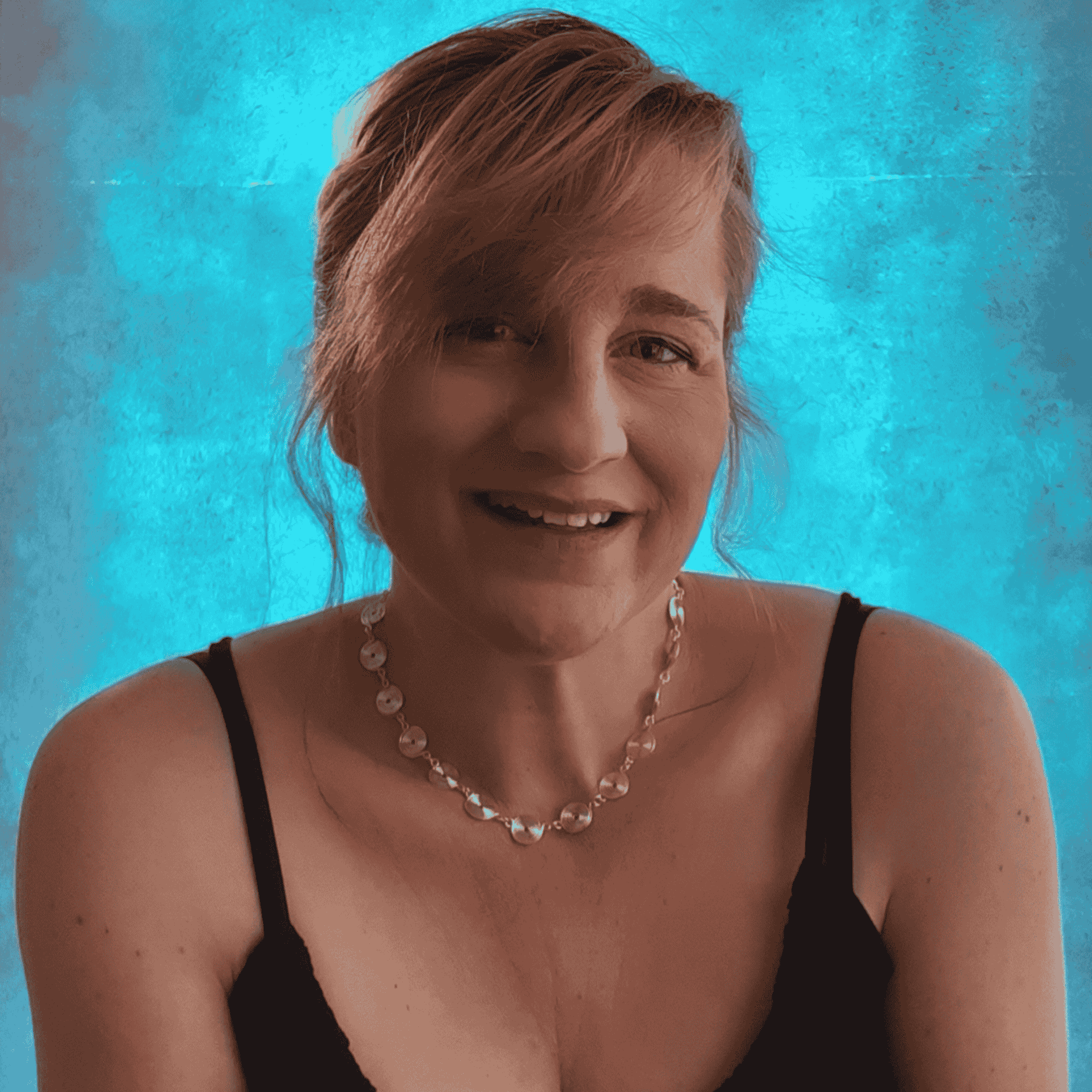 Woman wearing a black top and a silver spiral necklace against a blue background